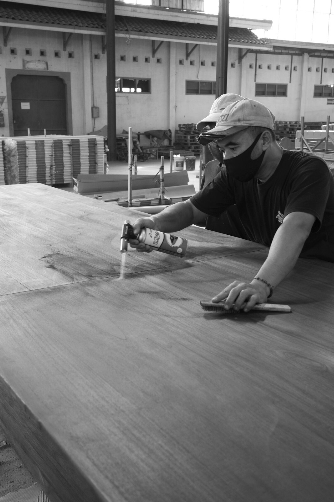 Baroba artisan hand-sanding a teak panel in the Jepara workshop